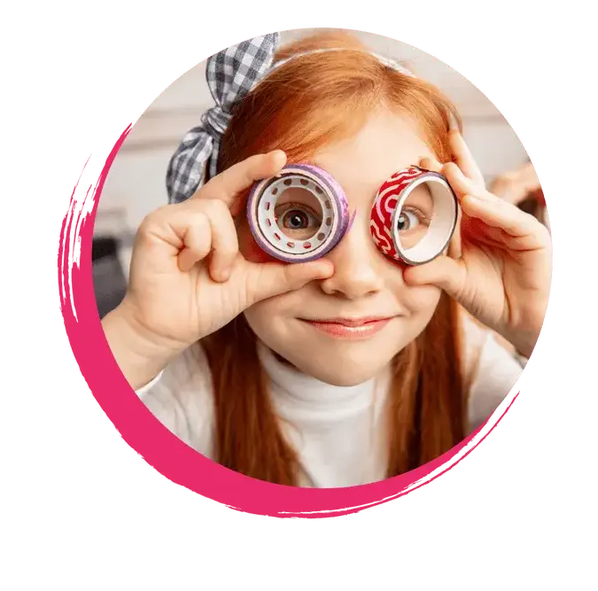 Ein Kind schaut gespannt durch Klebebandrollen.